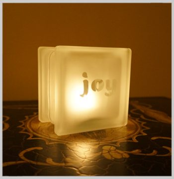 Glass block glass tealight candle holder with joy motif